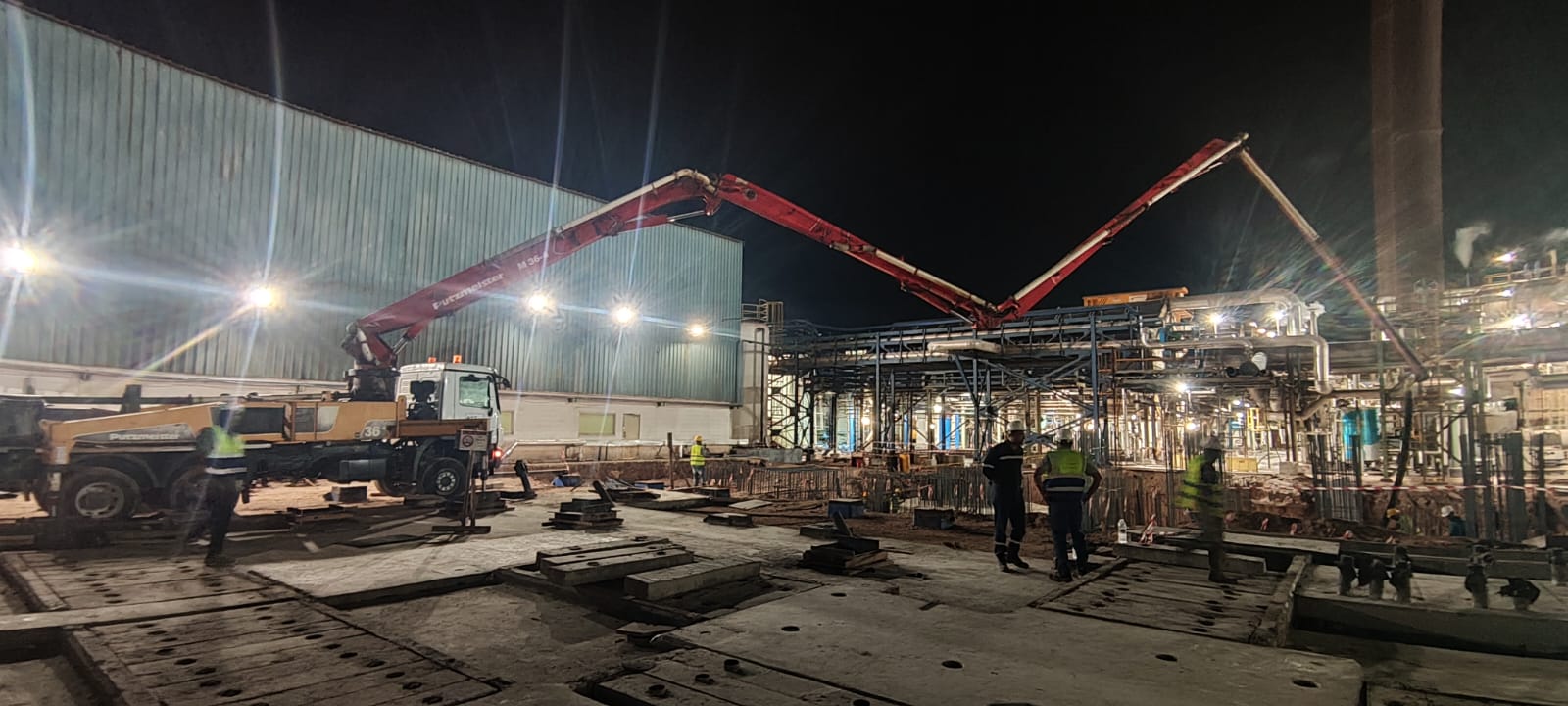 Twin boom pumps placing concrete at night