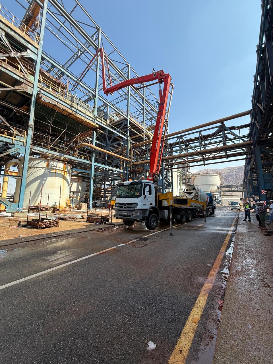 Boom pump placing concrete inside an industrial plant